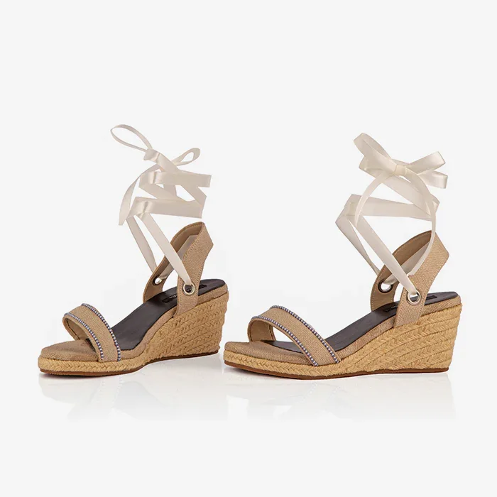 A pair of cream open-toed platform espadrilles with black straps and a wedge heel, featuring a leather lining