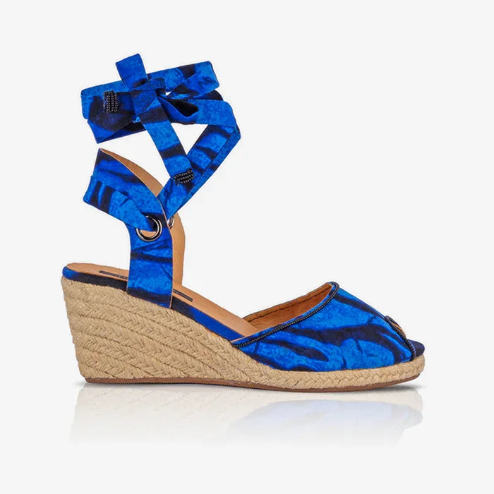 Blue wedge sandal with espadrille sole on a white background