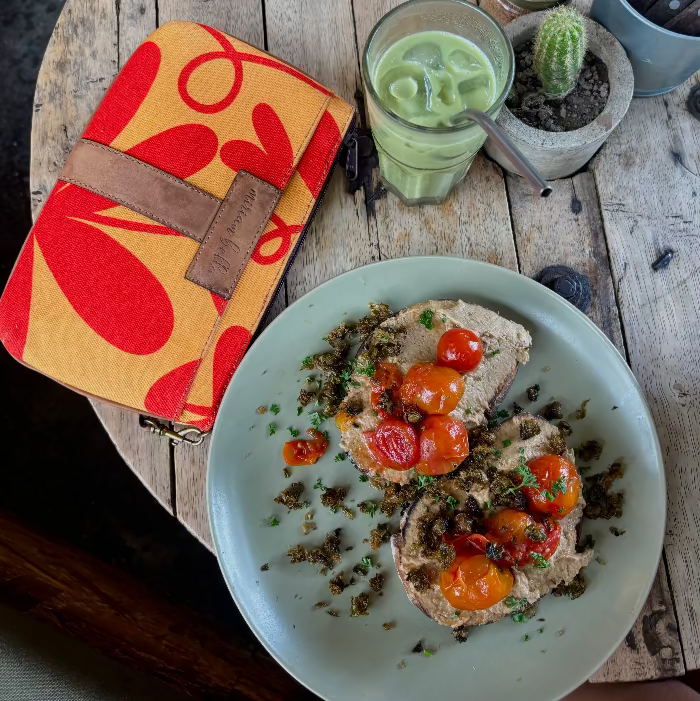 Plate of food with a drink and wallet on a wooden table