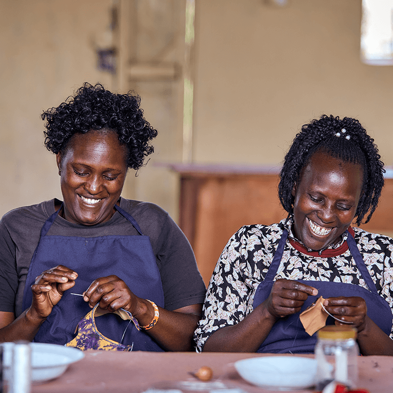 Close-up of artisan hand stitching leather thong sandals in Miriam Bella workshop, Kenya