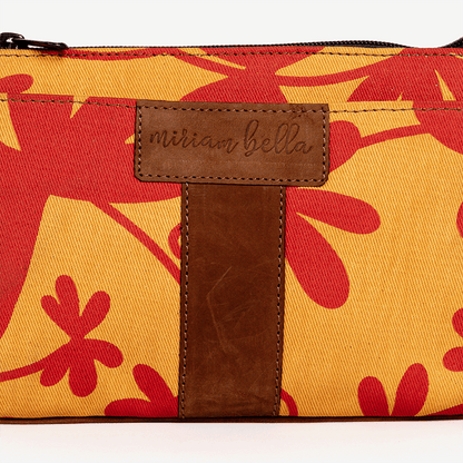 Floral-patterned pouch with a brown leather tag on a white background