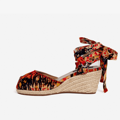 Wedge sandal with floral strap on a white background