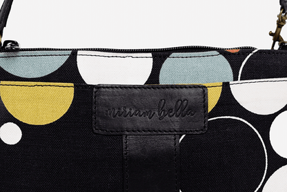 Black pouch with geometric patterns and 'arian bella' branding on a light gray background