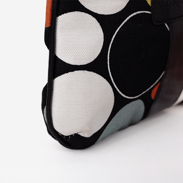Close-up of a fabric pouch with circular patterns on a white background