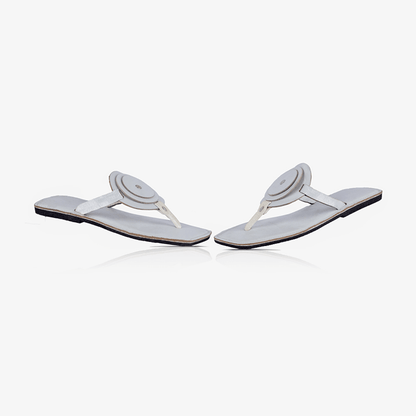 Image of a pair of white handmade leather flat sandals with a circle design produced by Australian brand Miriam Bella