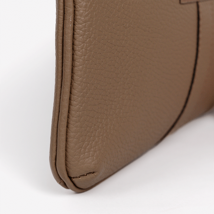 Close-up of a brown leather wallet corner on a white background