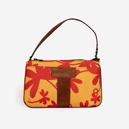 Handbag with red floral pattern and brown strap on a white background