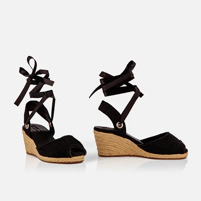 Side view of Gaia black canvas closed toe espadrille wedge heels with black ribbon ankle ties.