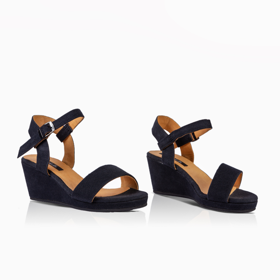 A pair of black wedge sandals with wide front straps and adjustable ankle straps, shown on a clean white background.
