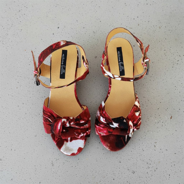 Red floral espadrille wedge sandals on a gray surface