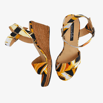 Pair of high-heeled sandals with a colorful pattern on a white background